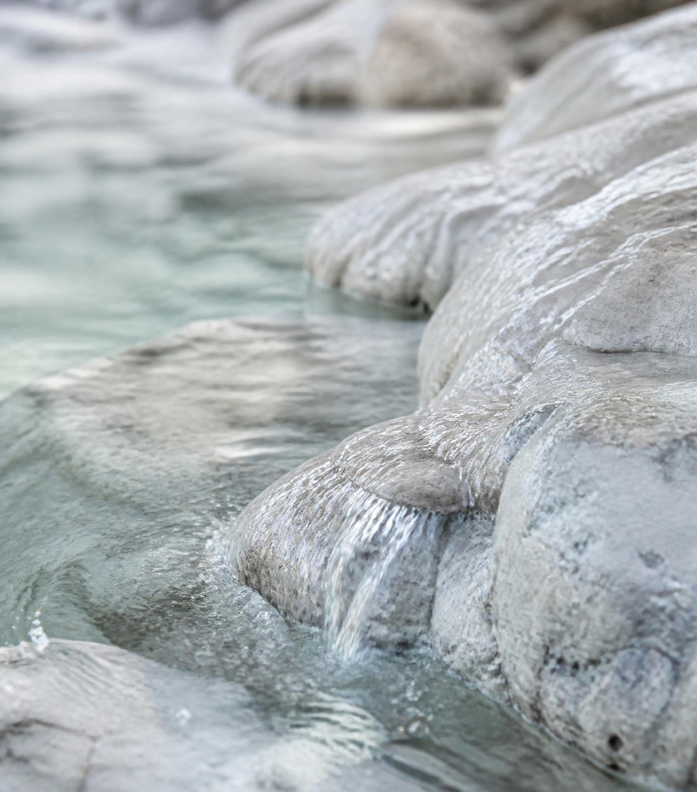 Cold spring water running over pale limestone rock